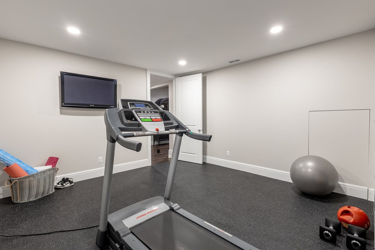 home-gym-with-a-treadmill-tv-and-rubber-flooring-southeast-mi-optimized