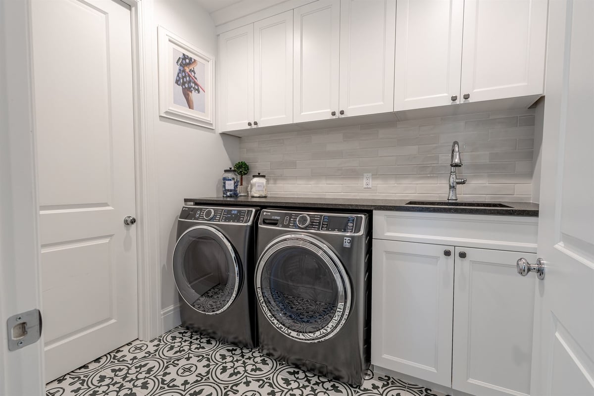laundry-room-with-a-front-load-washer-and-dryer-and-patterned-tile-floor-southeast-mi-optimized