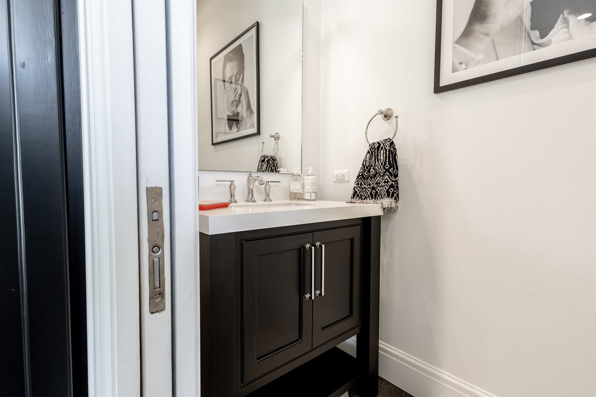 powder-room-with-a-black-vanity-marble-top-and-framed-art-southeast-mi-optimized