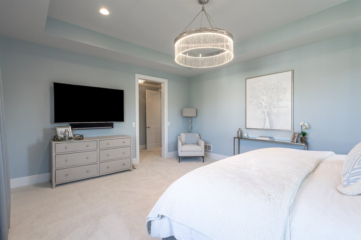 primary-bedroom-with-a-tray-ceiling-chandelier-and-sitting-area-southeast-mi-optimized