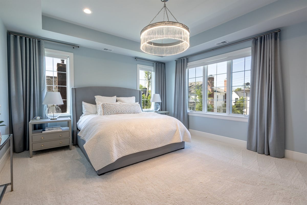 primary-bedroom-with-a-tray-ceiling-drum-chandelier-and-upholstered-bed-southeast-mi-optimized