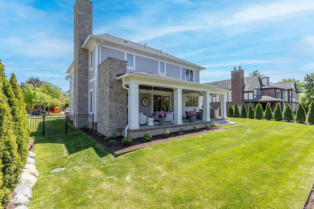 rear-exterior-with-a-stone-chimney-and-a-columned-covered-porch-southeast-mi-optimized