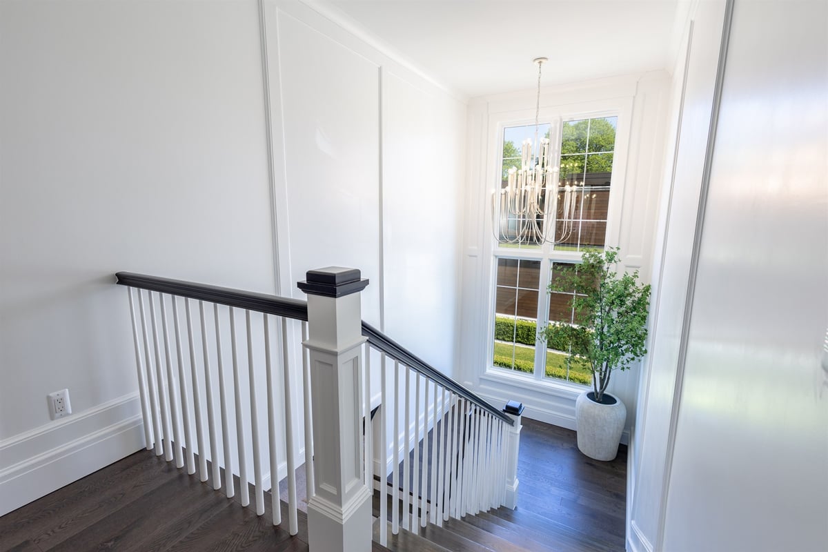 stair-landing-with-white-balusters-a-dark-handrail-and-a-chandelier-southeast-mi-optimized