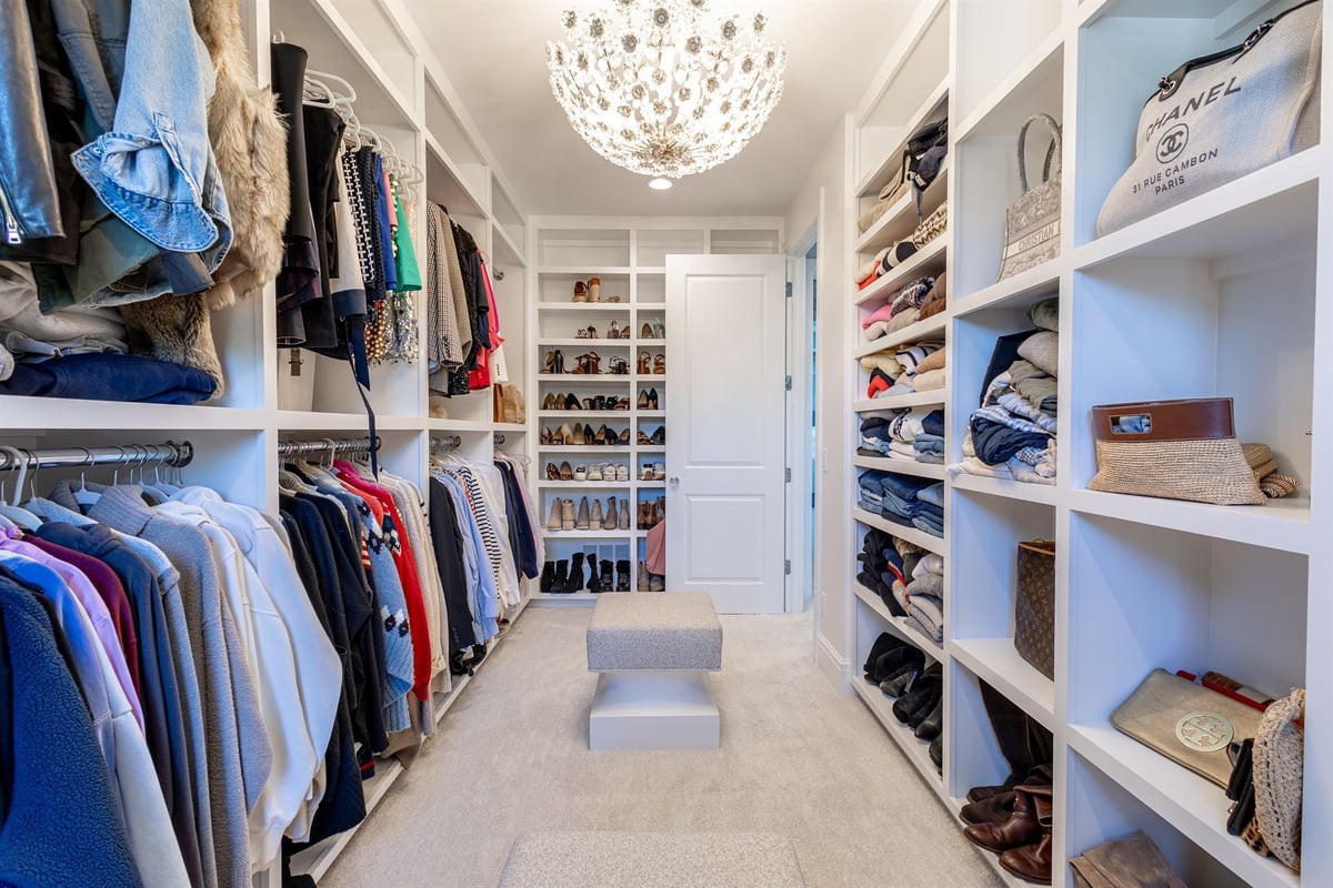 walk-in-closet-with-white-built-ins-shoe-shelving-and-a-bench-southeast-mi-optimized