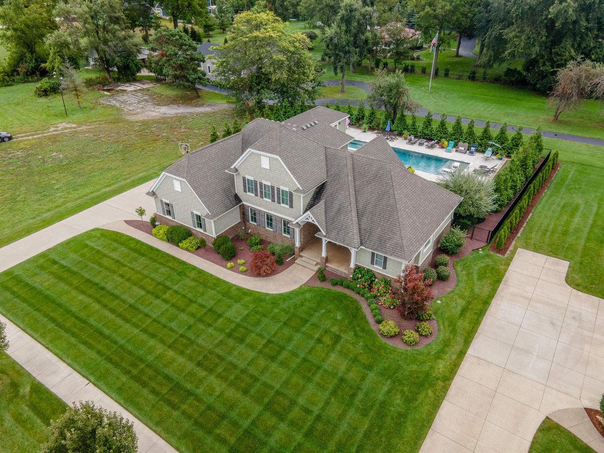 aerial-front-and-side-of-the-home-with-driveway-and-pool-beyond-southeast-mi-optimized