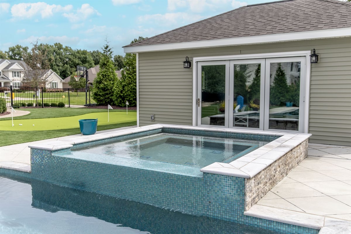 raised-spa-with-glass-tile-beside-the-pool-and-pool-house-southeast-mi-optimized