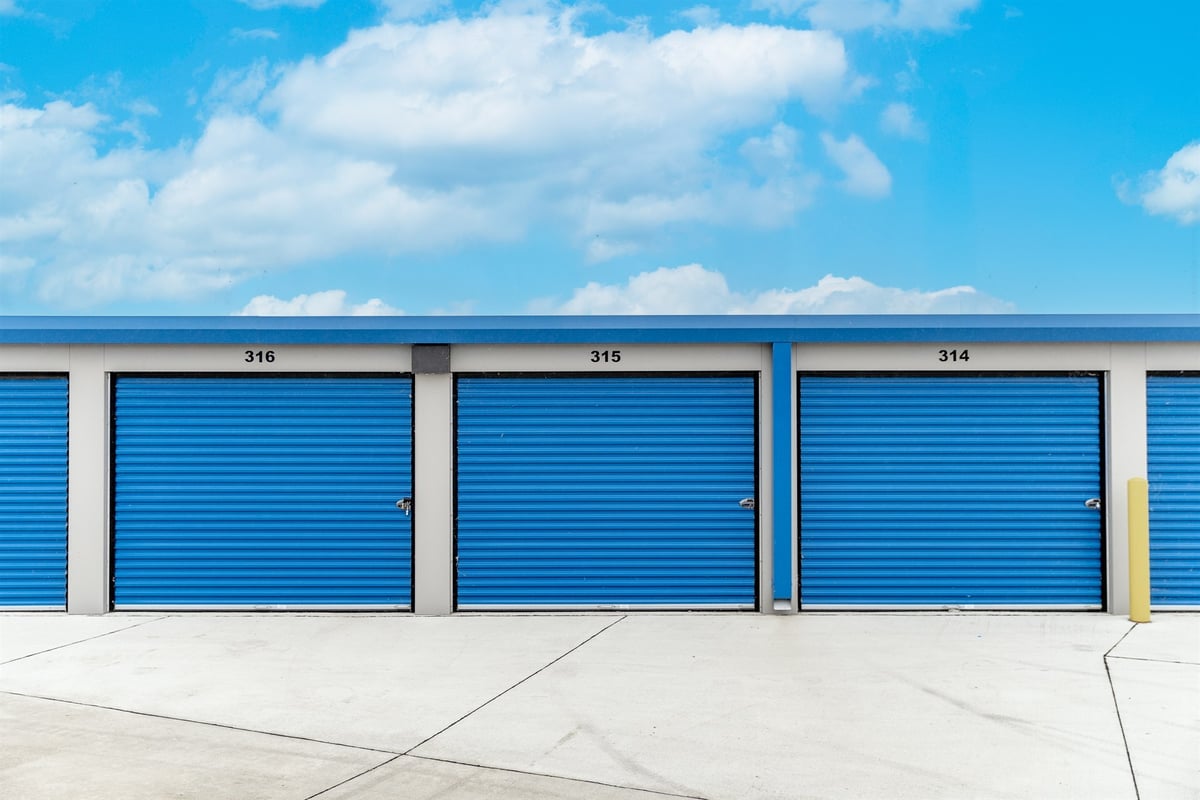 exterior-row-of-blue-unit-doors-under-a-bright-sky-commercial-self-storage-southeast-mi-optimized