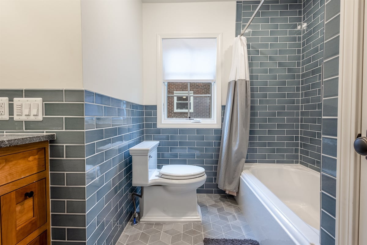 bathroom-with-blue-subway-tile-a-tub-shower-and-a-wood-vanity-southeast-mi-optimized