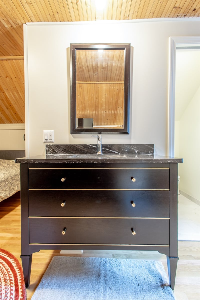 close-view-of-a-black-vanity-with-a-marble-top-and-framed-mirror-southeast-mi-optimized