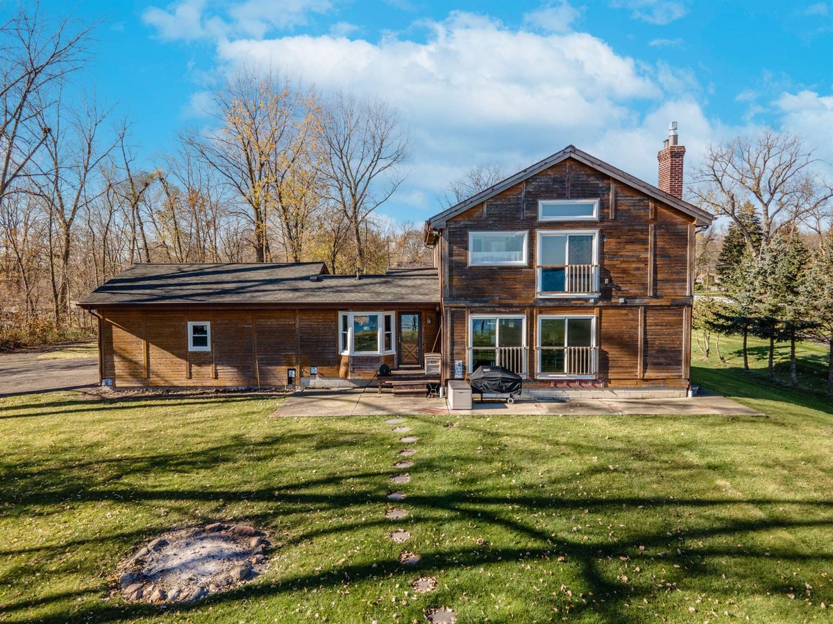 brown-wood-home-before-renovation-rear-with-a-patio-and-fire-pit-grosse-ile-mi-optimized