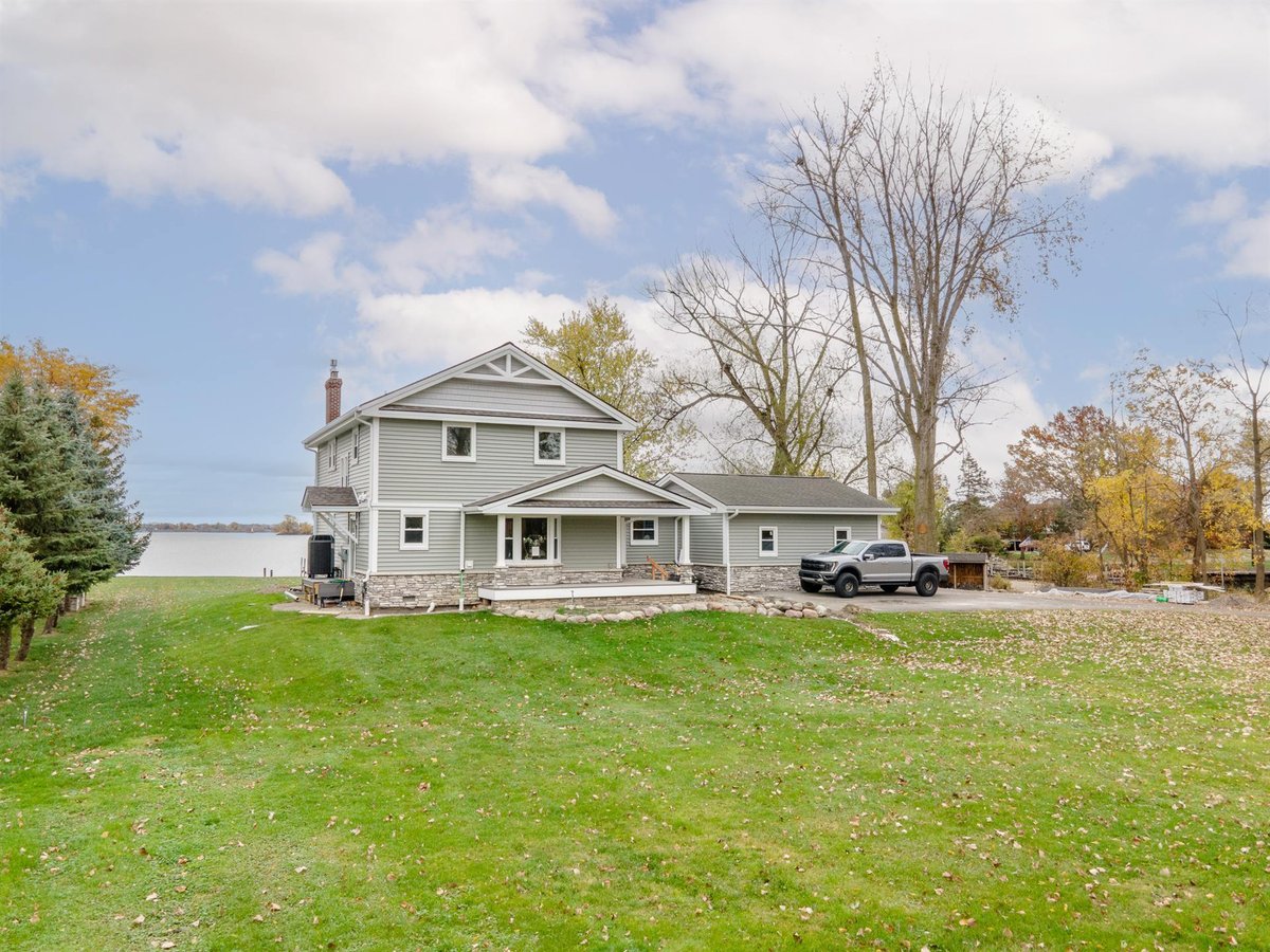 renovated-gray-home-aerial-rear-with-attached-garage-and-water-beyond-grosse-ile-mi-optimized