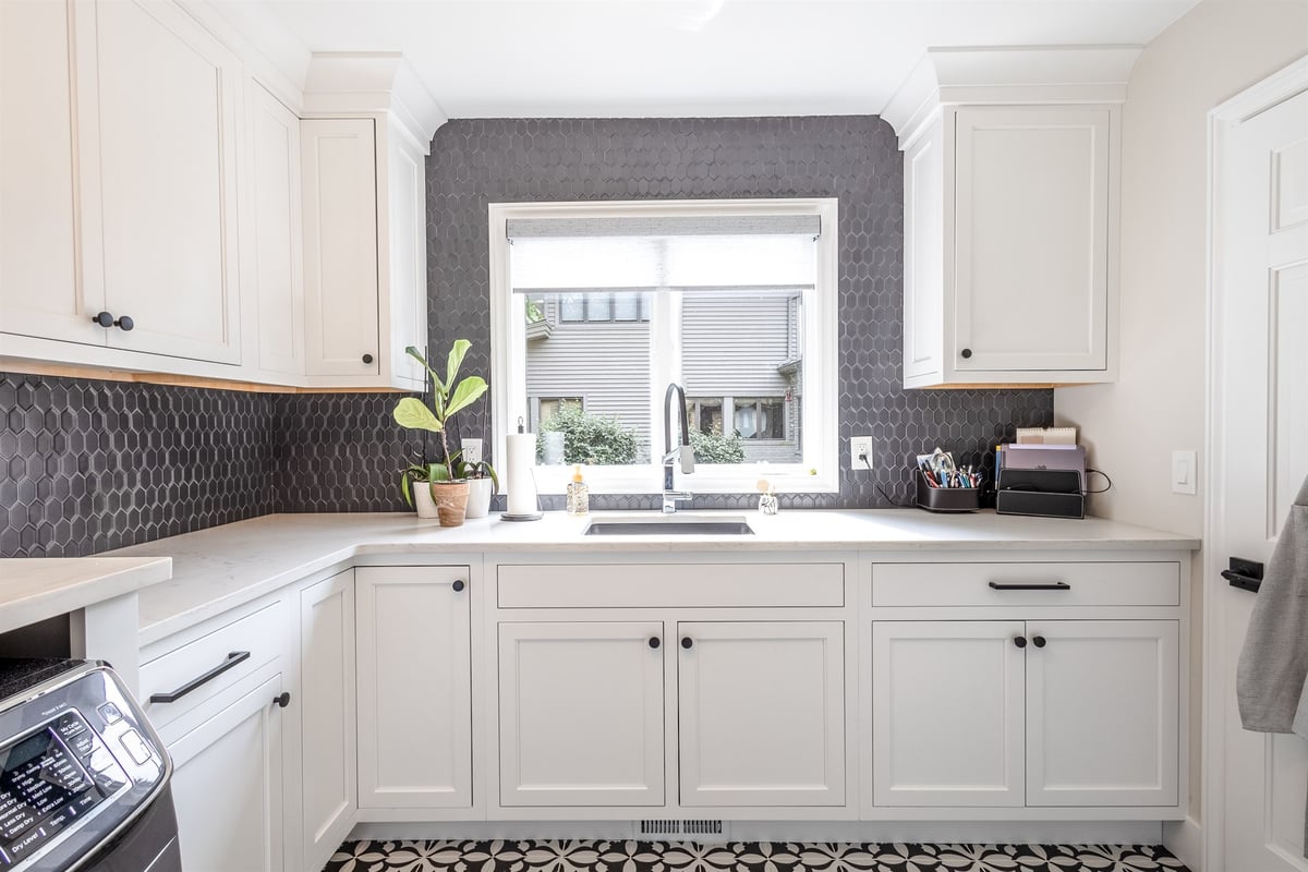 laundry-room-with-white-cabinets-black-hex-backsplash-and-a-window-southeast-mi-optimized