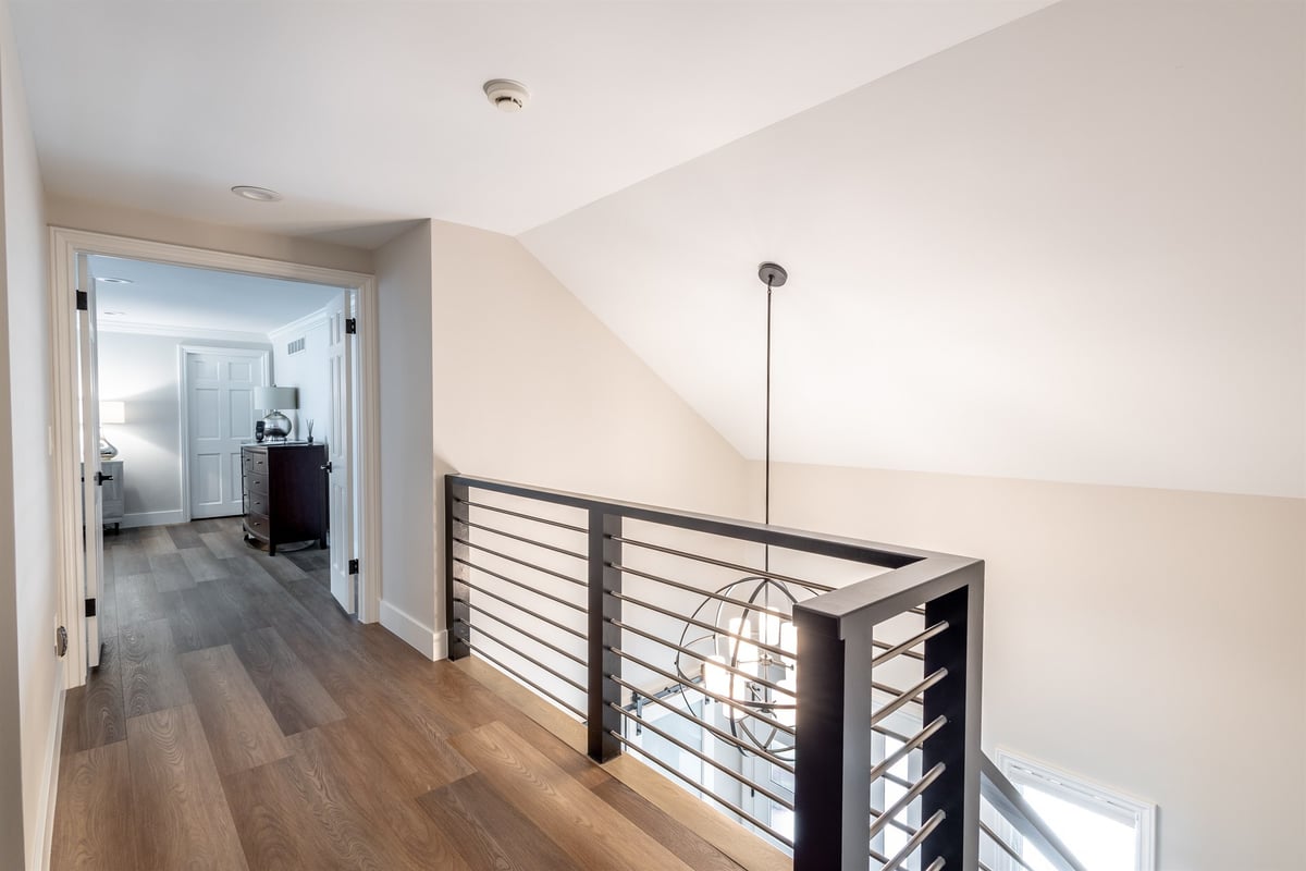 upstairs-landing-with-a-metal-railing-and-a-sphere-pendant-light-southeast-mi-optimized