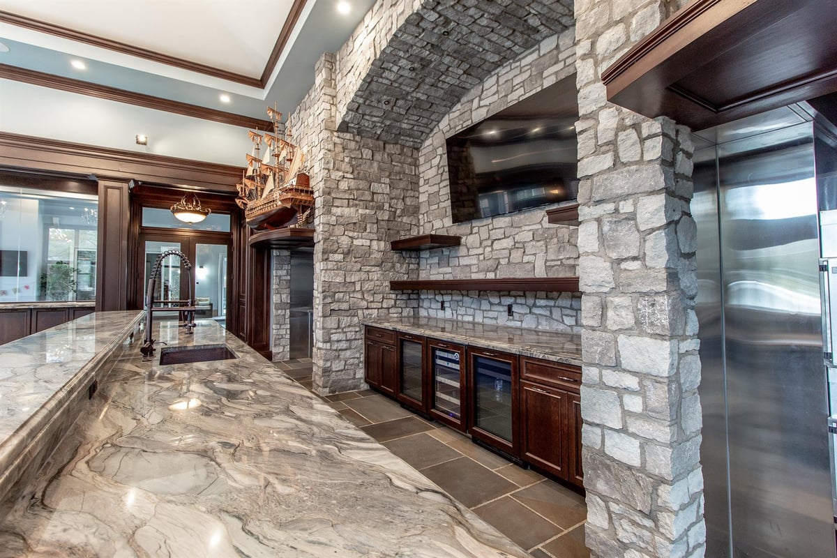 kitchen-with-a-granite-island-and-a-stone-fireplace-arch-with-a-tv-southeast-mi-optimized