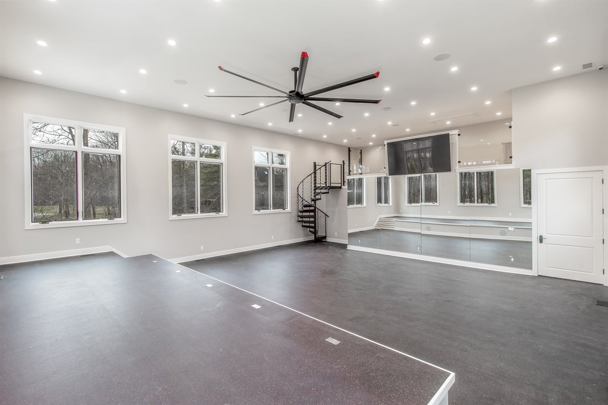 large-rec-room-with-dark-floors-a-spiral-staircase-and-an-oversized-fan-southeast-mi-optimized