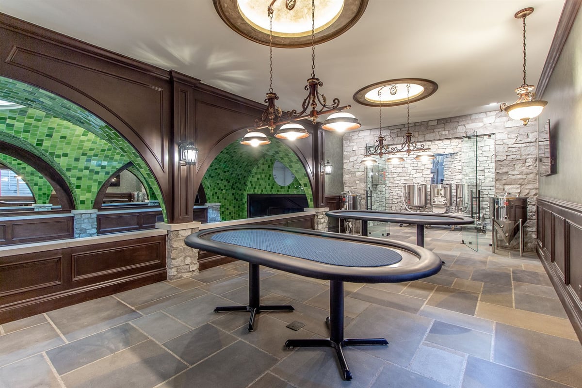 poker-room-with-an-oval-table-chandeliers-and-a-glass-wall-to-the-brewery-southeast-mi-optimized