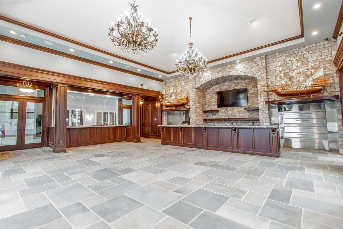 rec-room-with-a-dark-wood-bar-stone-fireplace-and-chandeliers-southeast-mi-1-optimized