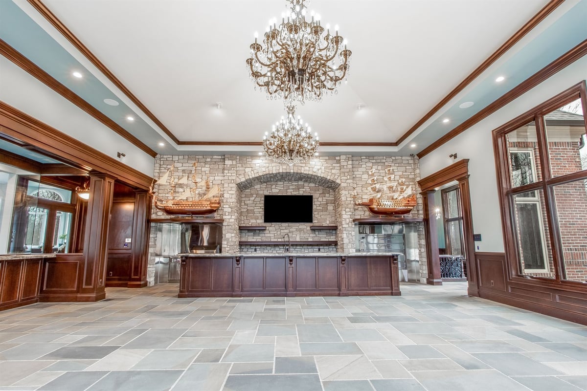 rec-room-with-a-dark-wood-bar-stone-fireplace-and-chandeliers-southeast-mi-optimized