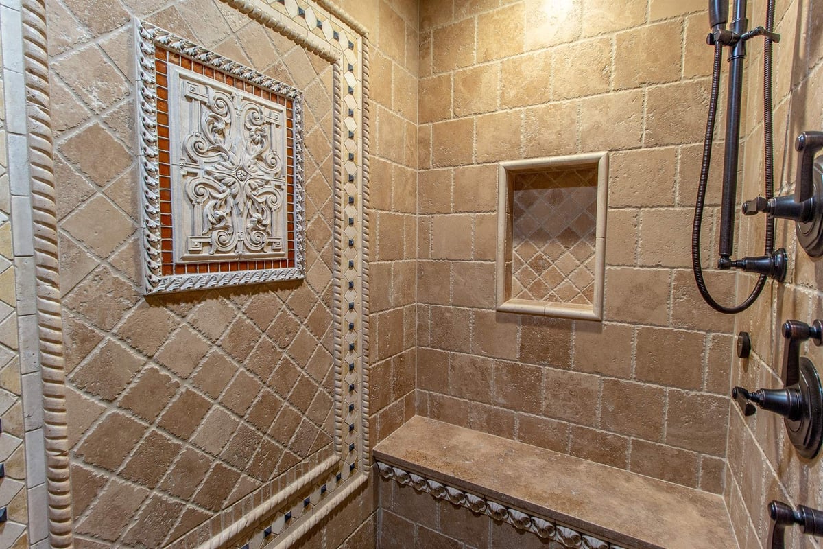 travertine-shower-with-a-decorative-medallion-niche-and-rain-head-southeast-mi-optimized