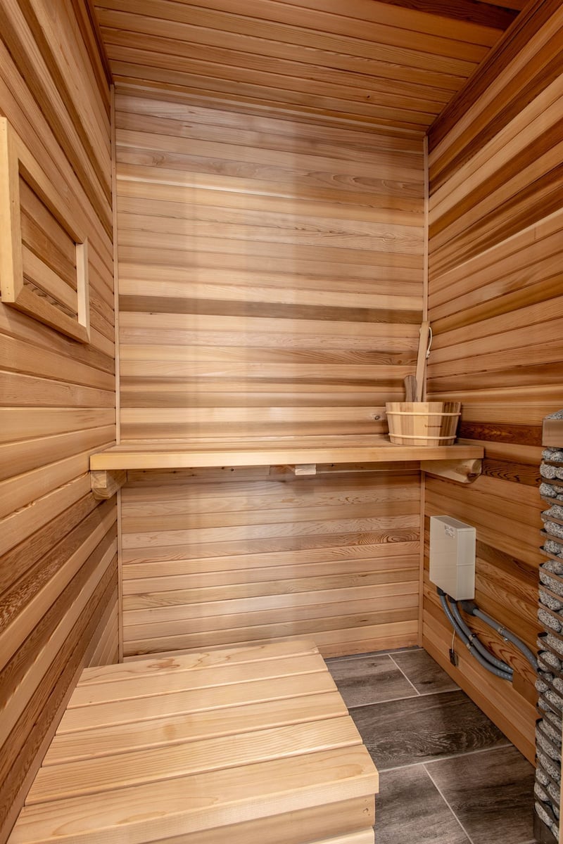 cedar-sauna-interior-with-bench-seating-heater-and-stone-accent-southeast-mi-optimized