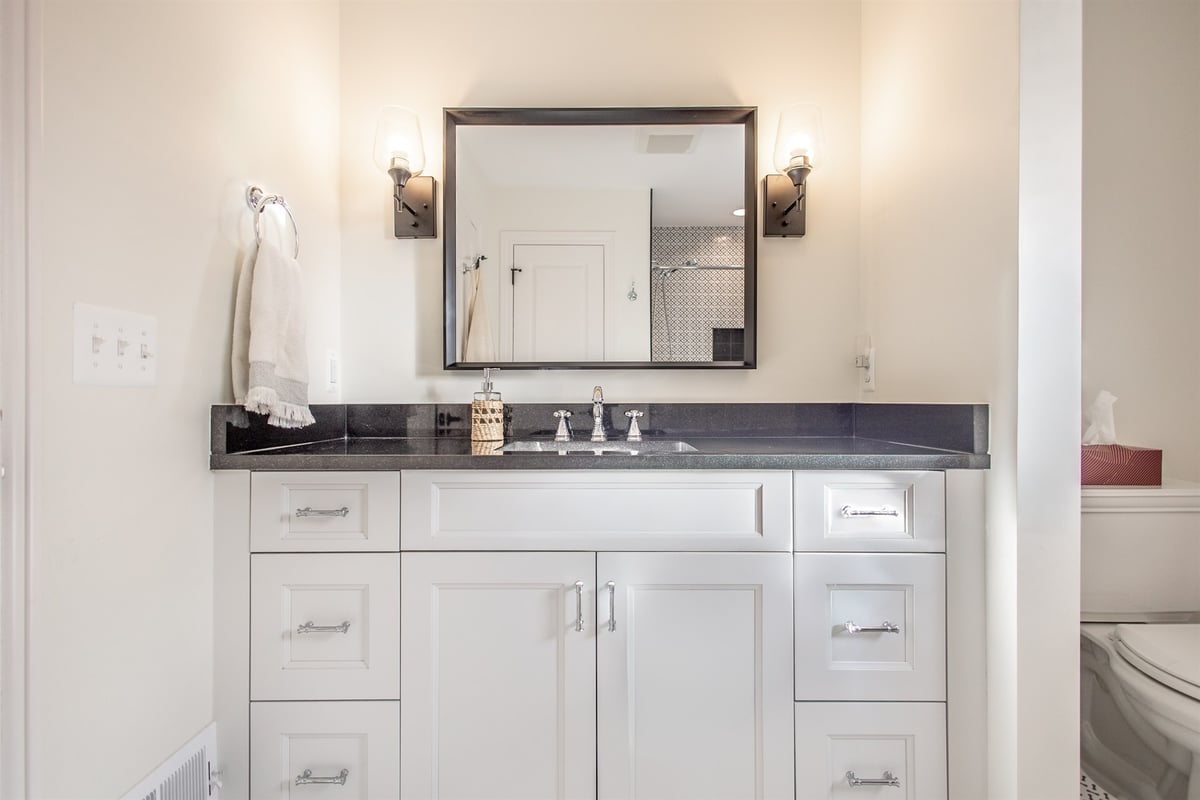 bathroom-vanity-after-renovation-with-a-dark-granite-top-and-framed-mirror-grosse-ile-mi-optimized