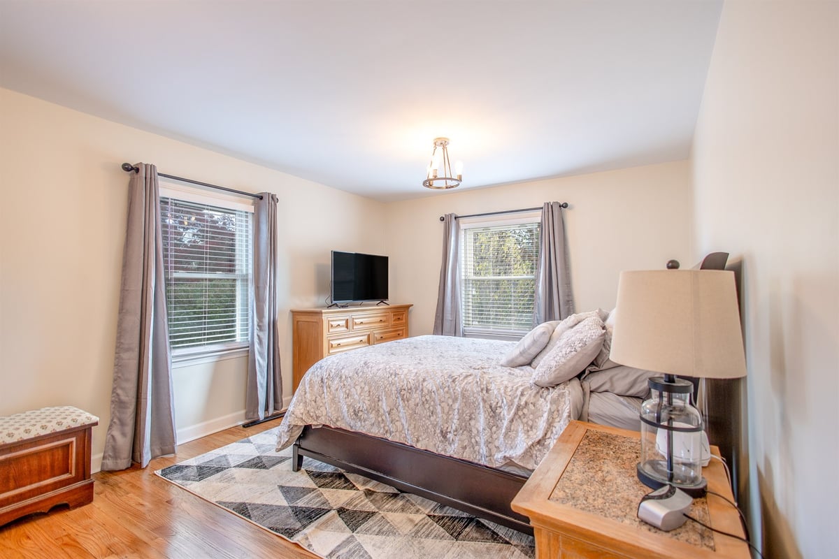bedroom-after-renovation-with-two-windows-and-hardwood-floors-grosse-ile-mi-optimized
