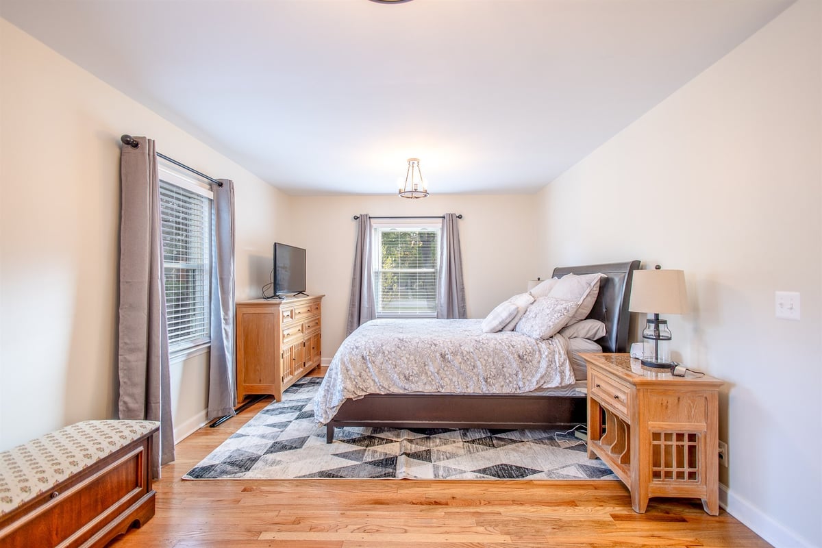 primary-bedroom-after-renovation-with-a-dresser-and-hardwood-grosse-ile-mi-optimized