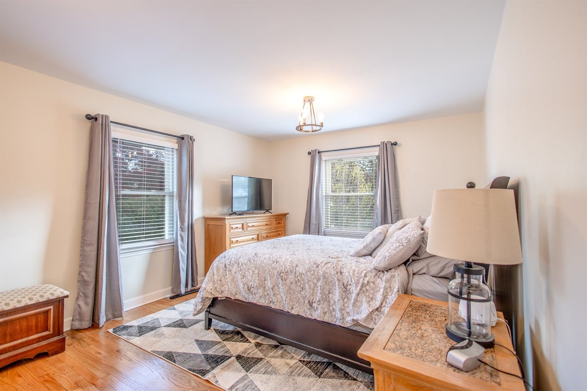 primary-bedroom-after-renovation-with-two-windows-and-hardwood-grosse-ile-mi-optimized