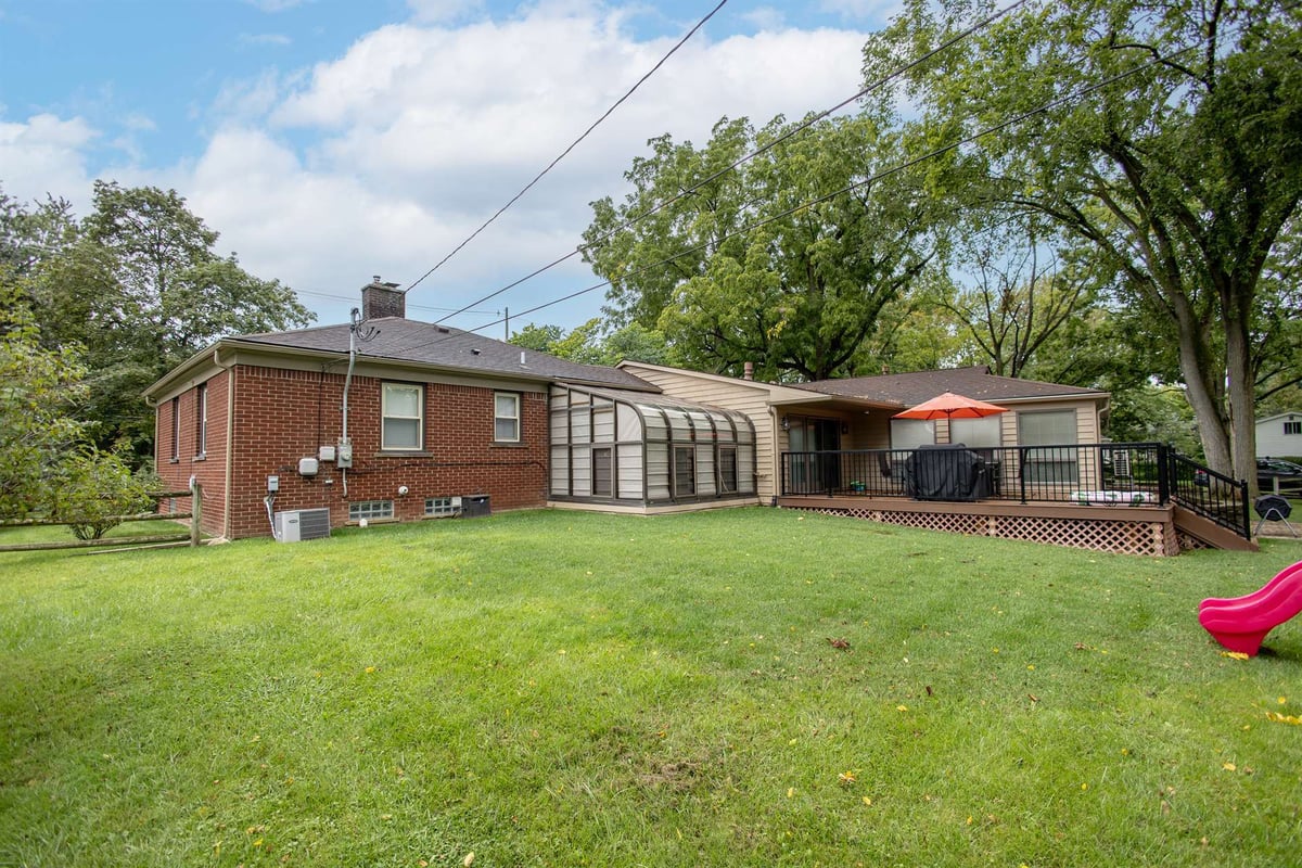 rear-exterior-before-renovation-with-a-sunroom-and-backyard-grosse-ile-mi-optimized