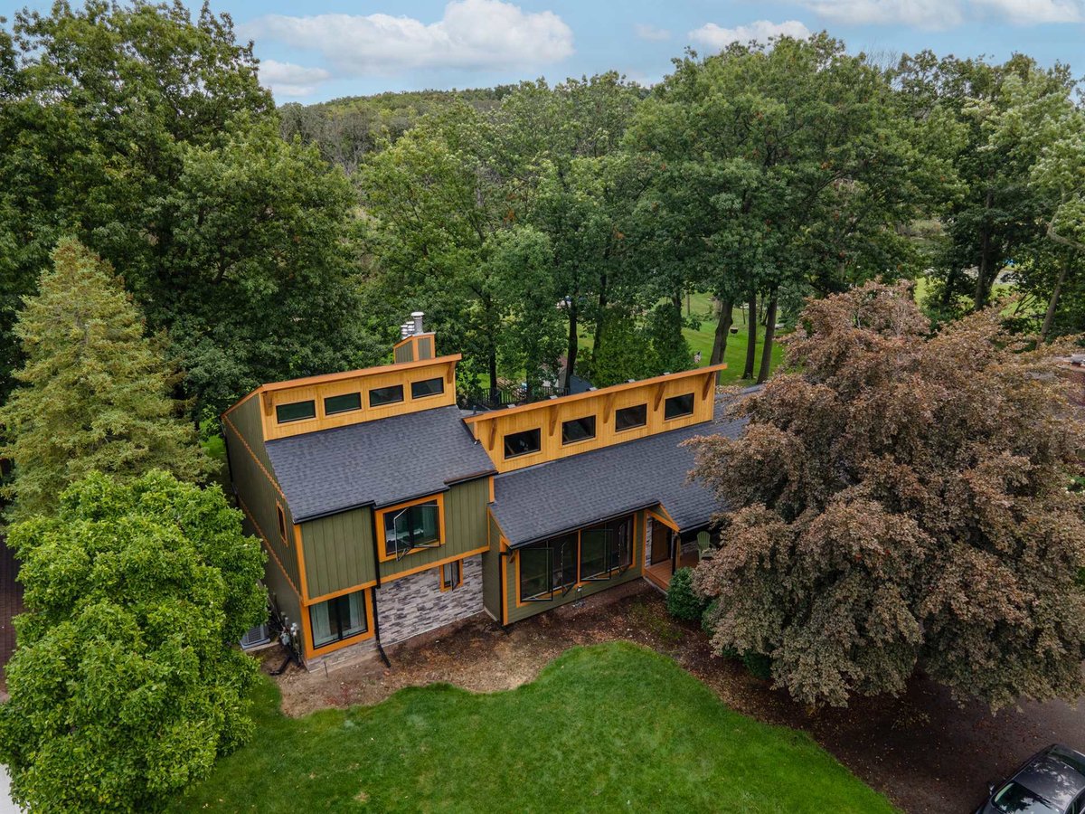 aerial-view-of-a-modern-home-with-olive-siding-and-cedar-trim-set-among-mature-trees-southeast-mi-optimized