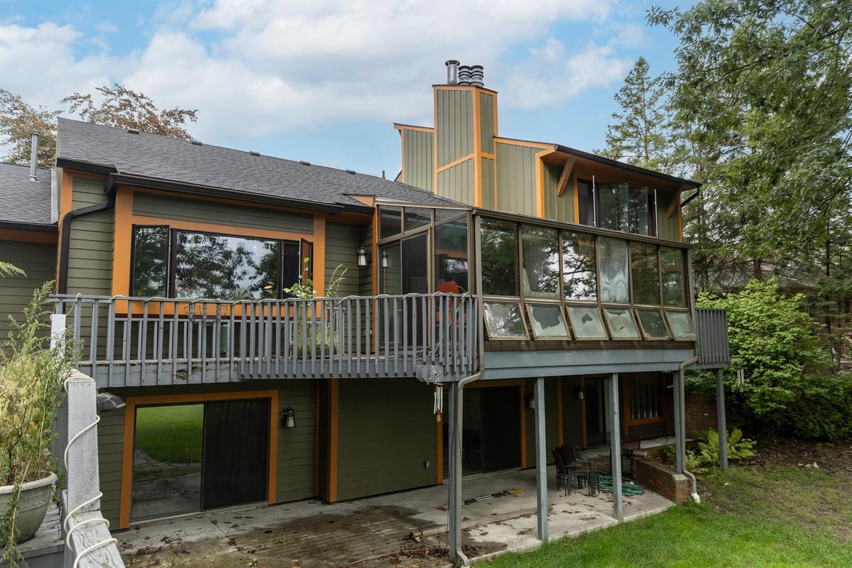 rear-exterior-with-a-covered-deck-sunroom-and-walkout-patio-below-southeast-mi-optimized