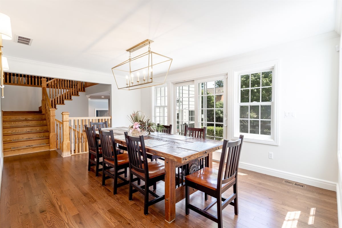 dining-area-with-a-reclaimed-wood-table-brass-chandelier-and-staircase-southeast-mi-optimized