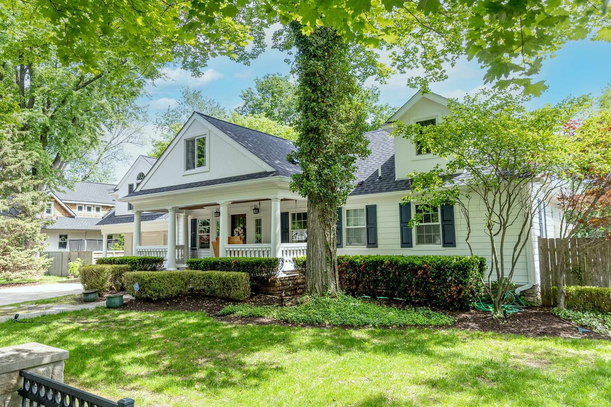 front-angle-of-a-white-two-story-home-with-a-covered-porch-and-mature-trees-southeast-mi-optimized