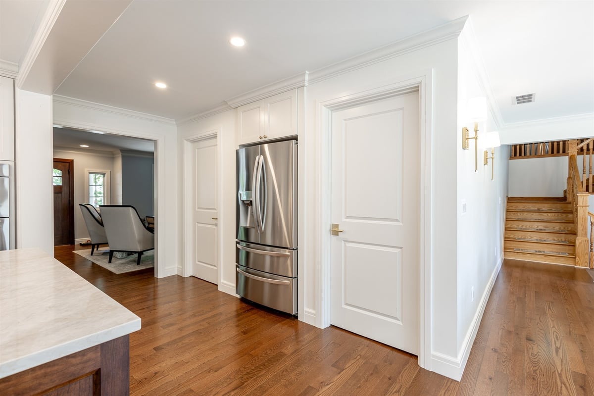 kitchen-hallway-with-a-stainless-refrigerator-pantry-and-staircase-southeast-mi-optimized