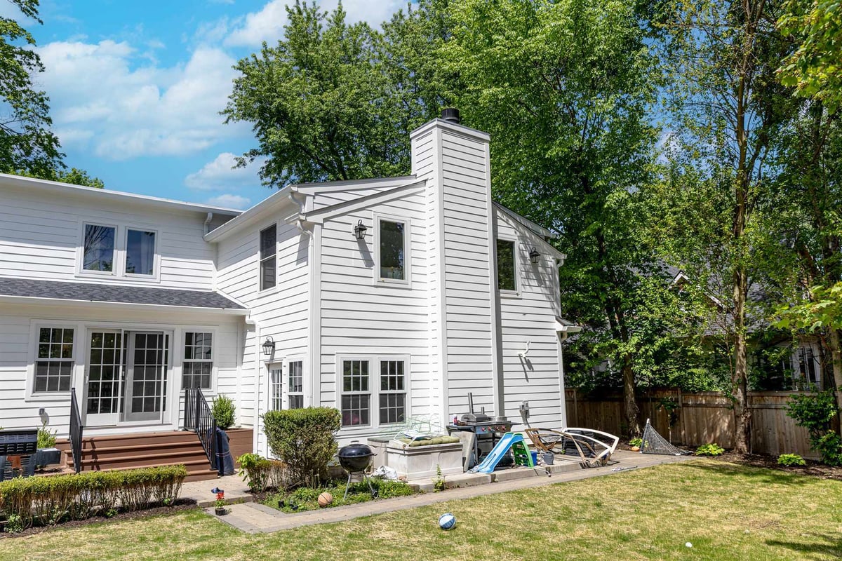 rear-and-side-of-a-white-home-with-siding-deck-and-chimney-southeast-mi-optimized