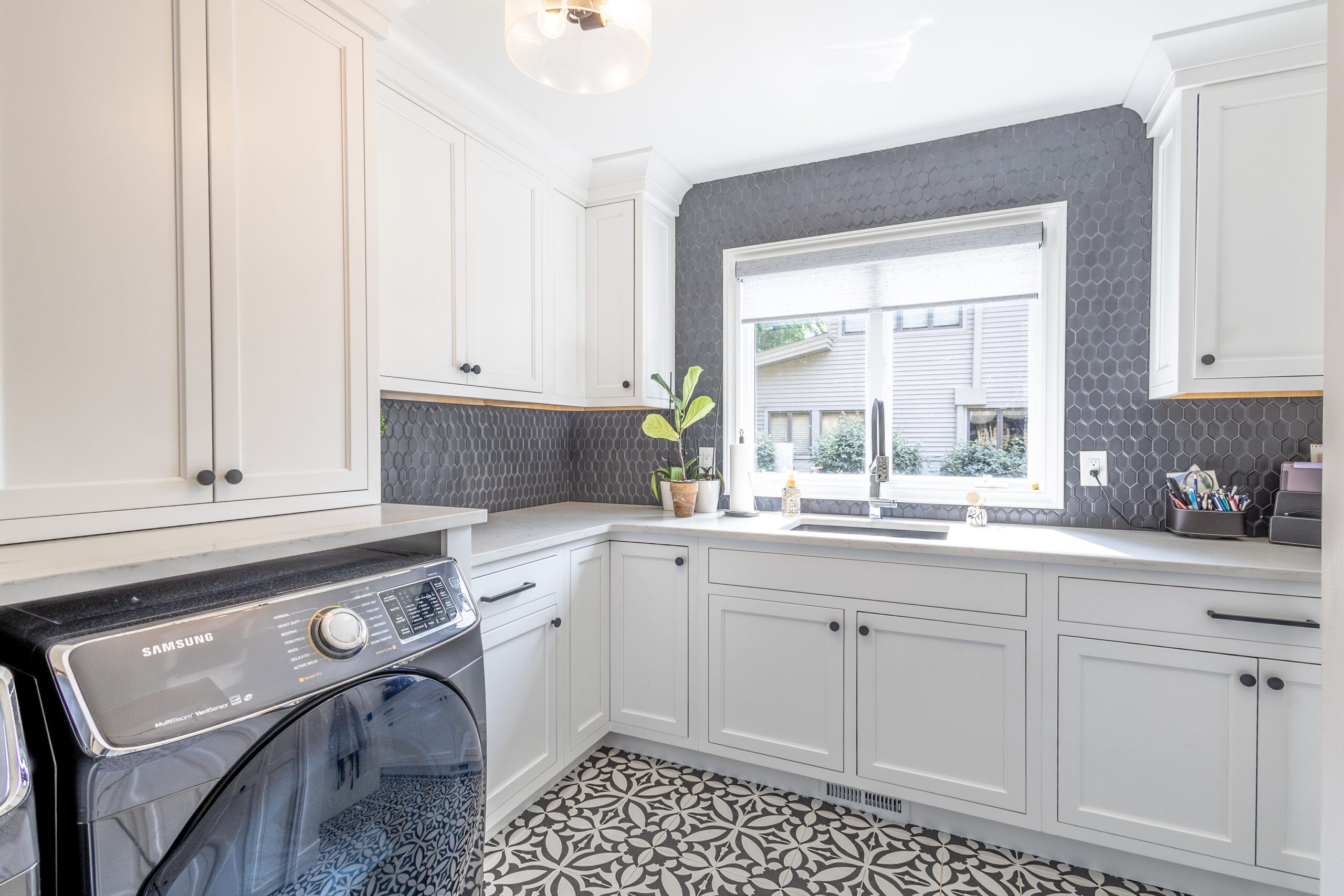 laundry room renovation with white cabinetry and patterned floor tile