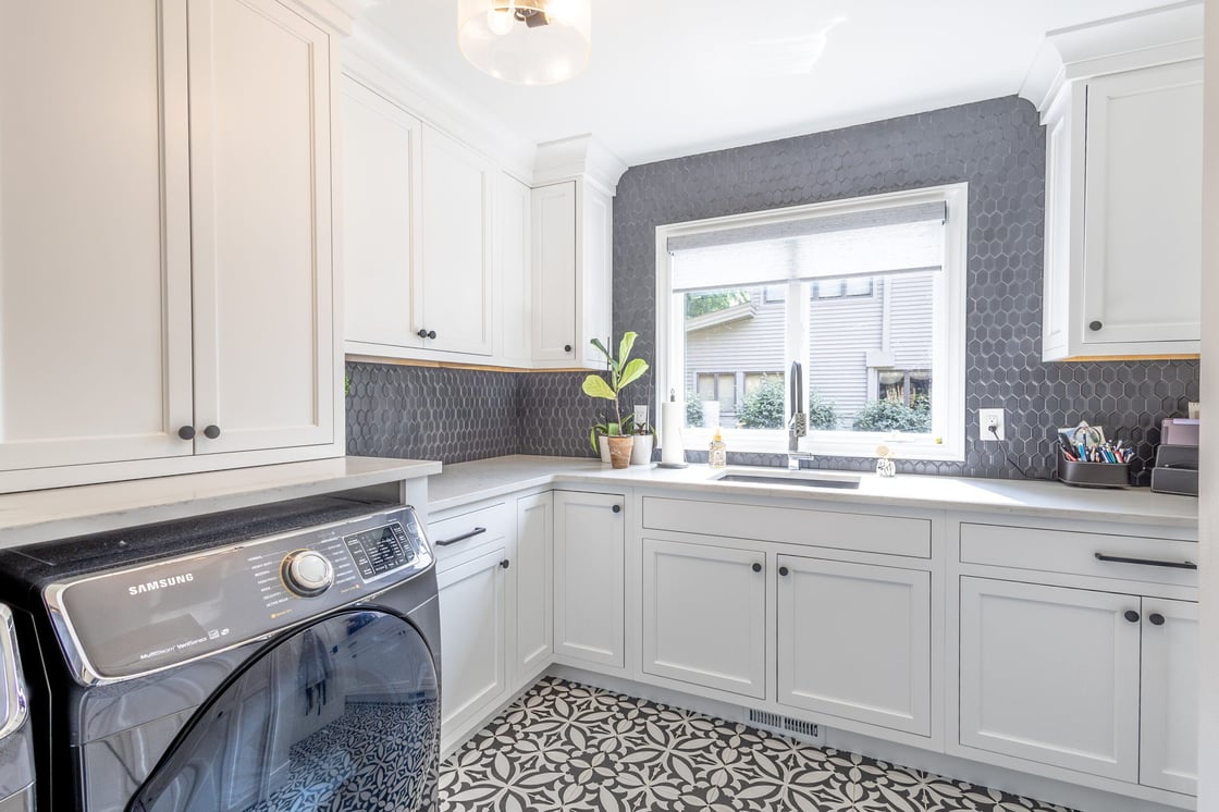 whole home remodel with finished laundry room with white cabinets and patterned floor tile