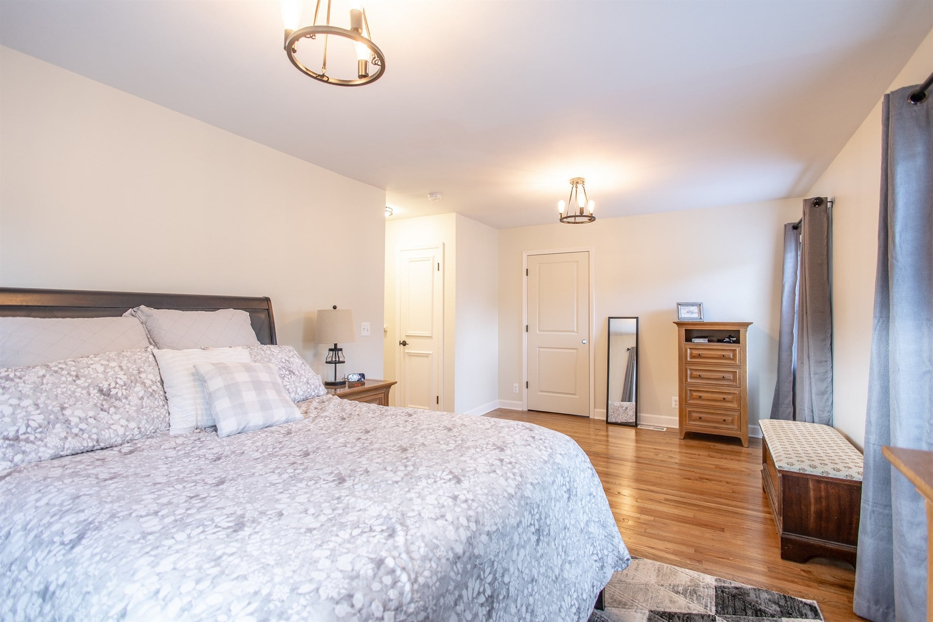 primary-bedroom-after-renovation-with-a-bed-and-hardwood-floors-grosse-ile-mi-optimized