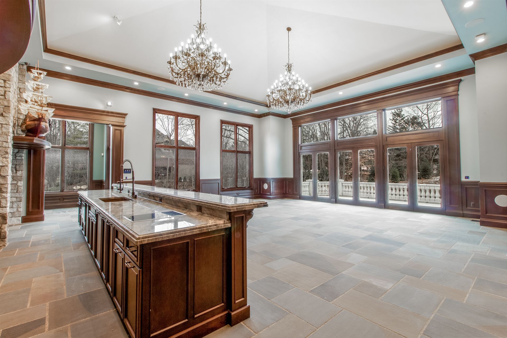 great-room-with-a-large-dark-wood-island-and-a-wall-of-windows-southeast-mi-optimized