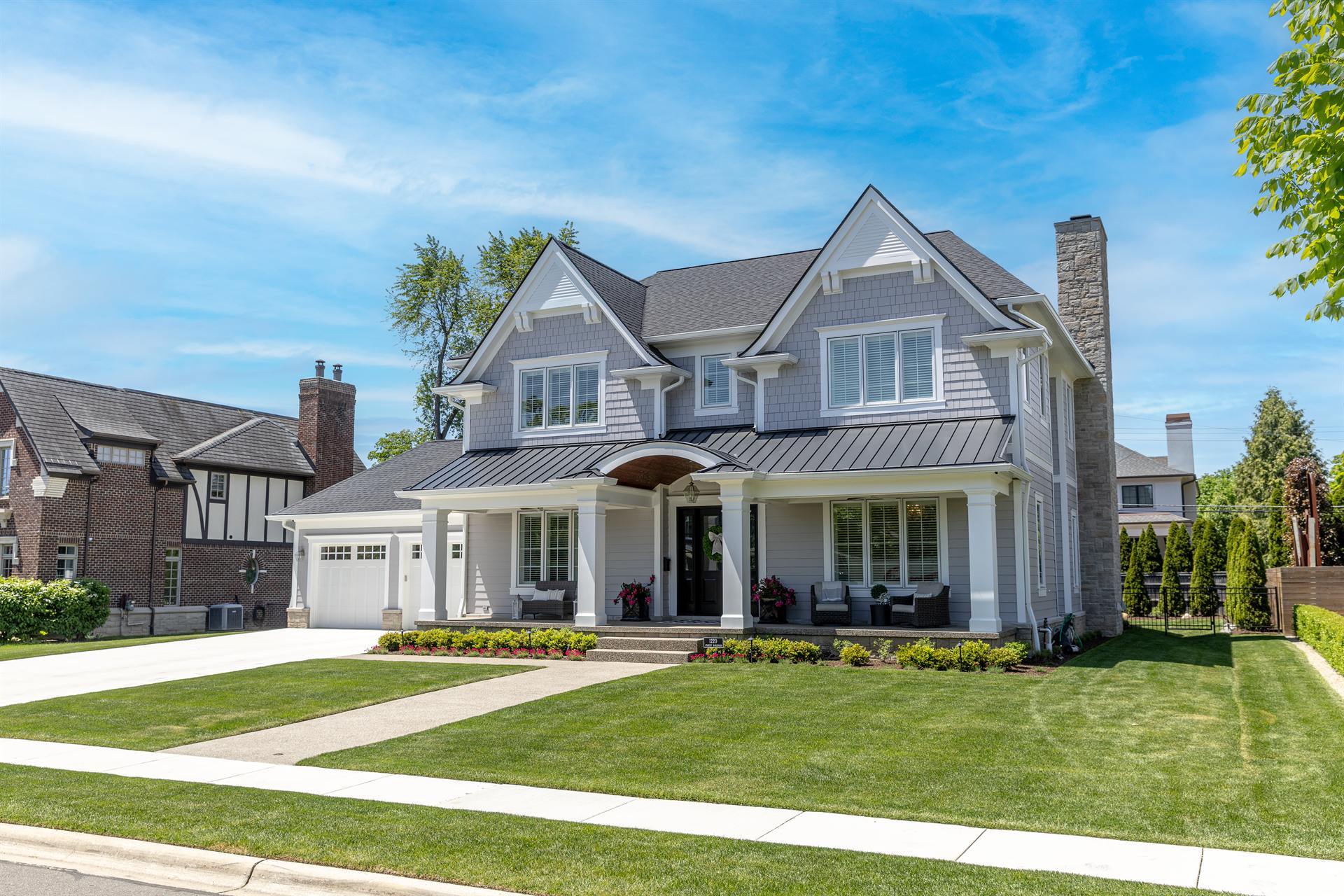 front-angle-of-a-gray-custom-home-with-a-covered-porch-and-stone-chimney-southeast-mi-optimized